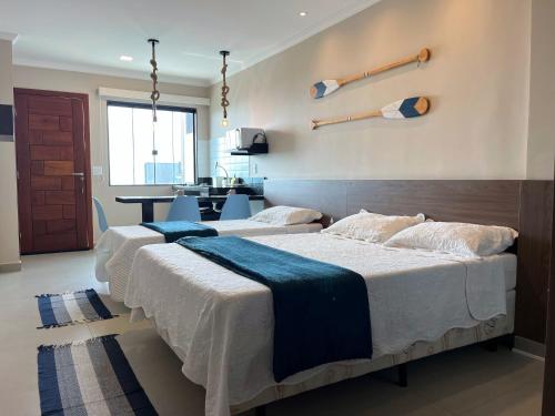 卡波布里奥Éolos Loft's - Cabo Frio的配有厨房的客房内的两张床