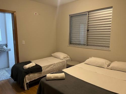 贝洛奥里藏特Locking´s Santo Agostinho 5 - Apto 2 quartos 2 vagas novo的客房设有两张床和窗户。