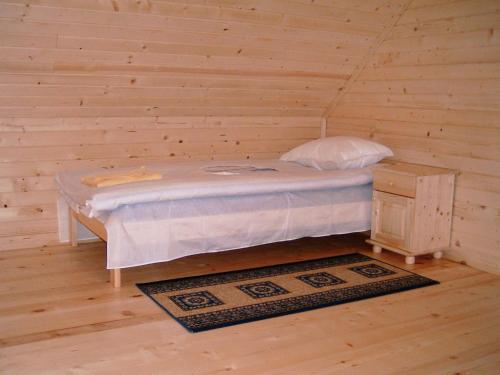 波罗维茨Chalet Sofia的木墙客房内的小床