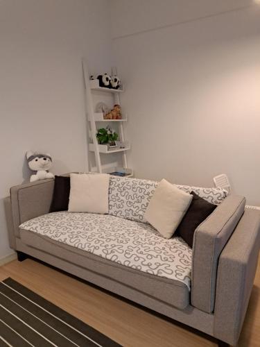 巴特沃思Woodsbury Suites IKEA House Butterworth Penang的客厅的沙发,带有白色的墙壁