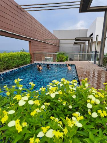 巴特沃思Woodsbury Suites IKEA House Butterworth Penang的三人在黄色花卉的游泳池里