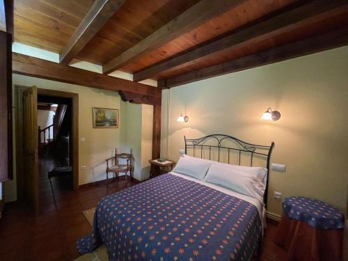 埃斯皮纳马Casa El Montero的一间带一张床的卧室,位于带木制天花板的房间内