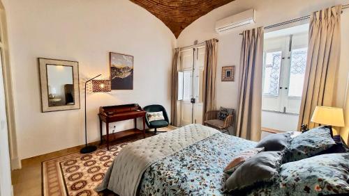 奥良Casa Victoria的一间卧室配有一张床、一张书桌和一面镜子