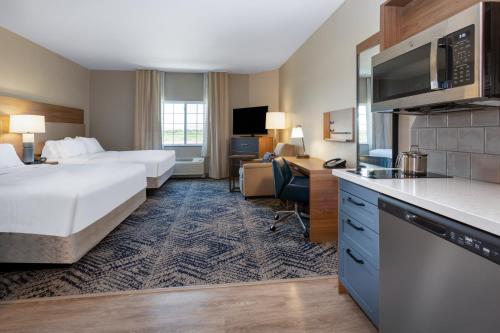 大章克申格兰德詹克森烛木套房酒店的酒店客房设有两张床、一张书桌和一个厨房。