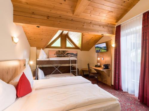 瑟尔Alpengasthof Gruberhof的一间带两张床的卧室,位于木天花板的房间