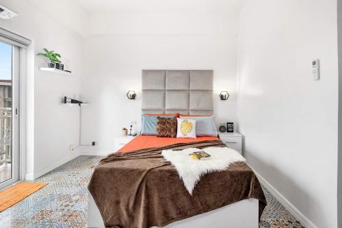 PusokHyllia by J&J (Near Airport . Wifi . Netflix )的白色卧室配有一张带橙色毯子的大床