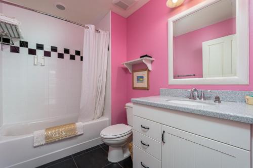迈尔斯堡海滩Harbour House at the Inn 214的粉红色的浴室设有盥洗盆、卫生间和镜子