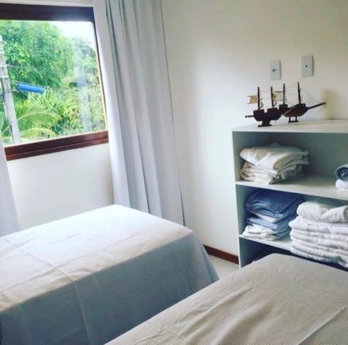 巴拉格兰德Barra Grande Pe na Areia Beira Mar的一间卧室配有床和带毛巾的窗户。