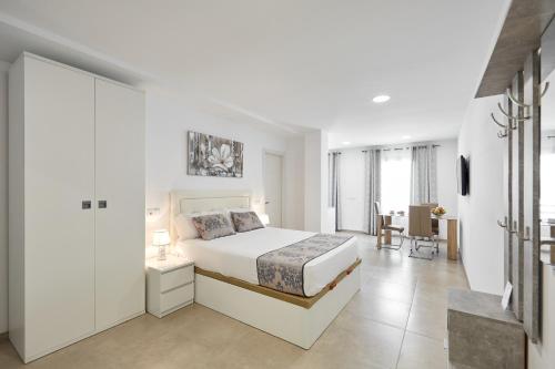 贝尼多姆Sonrisa Deluxe Apartments, Levante的白色卧室配有床和书桌