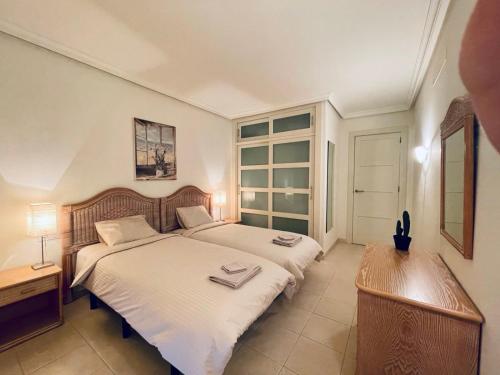 圣地亚哥港Casa Lea Los Gigantes的一间卧室设有两张床、一张桌子和一个窗口。