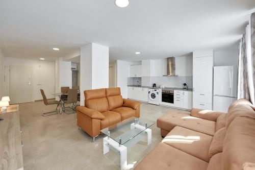 贝尼多姆Sonrisa Deluxe Apartments, Levante的带沙发和椅子的客厅以及厨房。