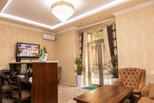 撒马尔罕AHMAD HOTEL的客厅配有餐桌和电视