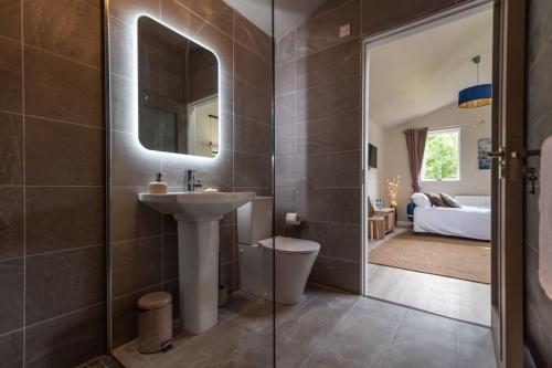 肯梅尔The Rose Suite Kenmare的一间带水槽和镜子的浴室以及一间卧室