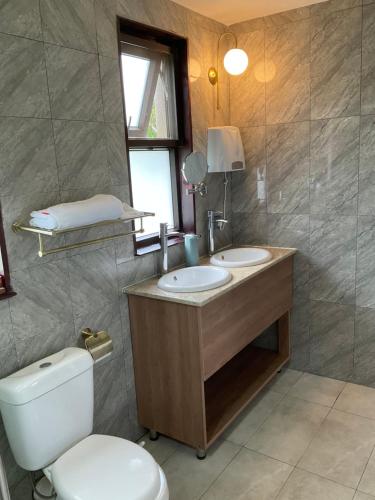HoimaZebi Ecolodge的一间带两个盥洗盆、卫生间和窗户的浴室