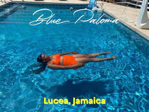 卢西Blue Paloma Bed & Breakfast的女人躺在游泳池里