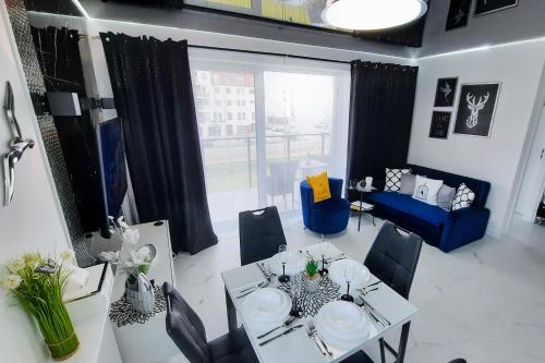 雷达Apartament 10 Glamour Aquapark Reda的一间带桌椅和窗户的用餐室