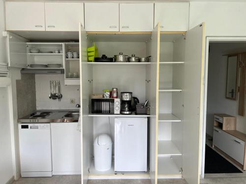 斯图加特Ruhiges und klimatisiertes Apartment的一间小厨房,配有白色的橱柜和书架