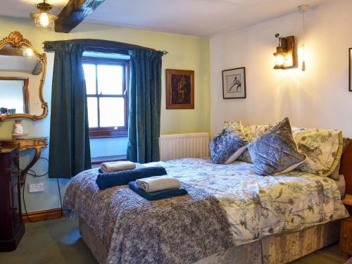阿尔斯通Robsons Cottage的一间卧室配有一张带两个枕头的床