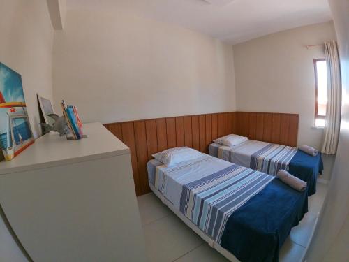 因巴塞Village em Imbassaí的一间卧室设有两张床、一张桌子和一个窗口。