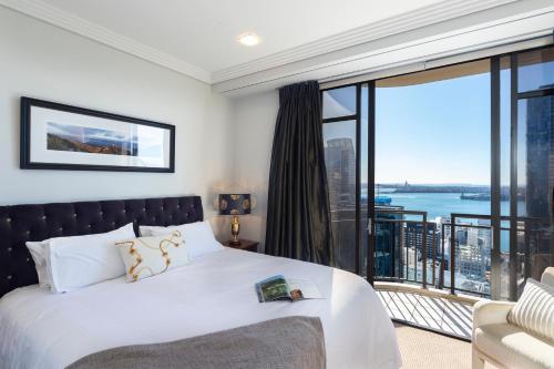 奥克兰Luxury Penthouse Apartment的一间卧室设有一张床和一个大窗户