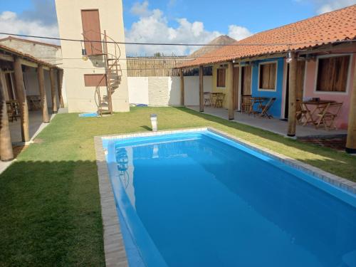 佩德拉斯港Pousada Ventos e Velas的一座房子后院的游泳池
