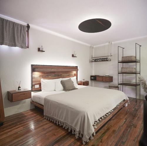 图卢姆Hotel Boutique TerraNova的卧室配有一张白色的大床,铺有木地板