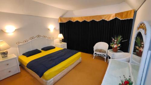 巴图Villa Klub Bunga Empat的一间卧室配有一张特大号床和一面镜子