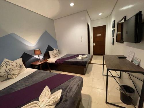 科隆Coron Ecolodge的酒店客房设有两张床和一台平面电视。