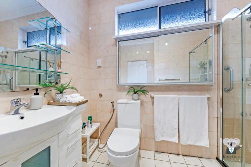 悉尼KozyGuru / Rockdale / Spacious Modern 2 Bedrooms Holiday Home NRO147的浴室配有卫生间、盥洗盆和淋浴。