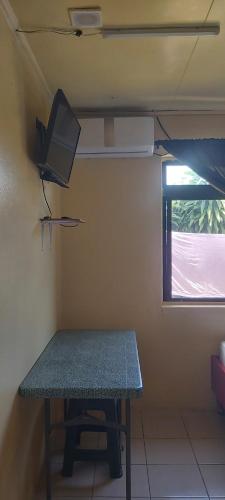 波拉波拉Raihei Auberge de jeunesse Chez l'habitant à Bora Bora的一间设有桌子和墙上电视的房间