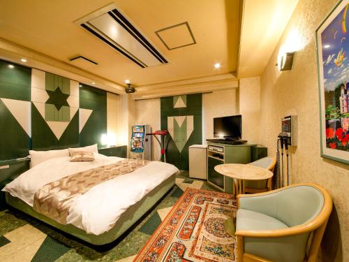 京都圣马丁酒店（成人专用）的一间卧室配有一张床、一张桌子和一台电视。