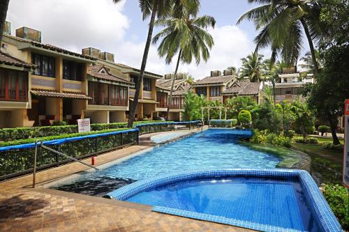 瓦尔恰Agosto @Aansav Verde Fatrade Varca GOA 3 BR Villa的棕榈树度假村内的游泳池