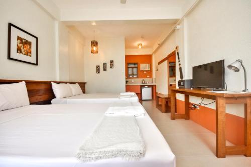 长滩岛长滩阿戈屋舍卧榻酒店的酒店客房设有两张床和电视。