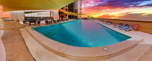 沙迦Luxe Grand Hotel Apartments的大楼顶部的大型游泳池