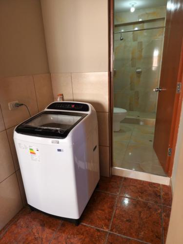 阿雷基帕Departamento Amoblado Arequipa的带淋浴的浴室内的洗衣机和烘干机