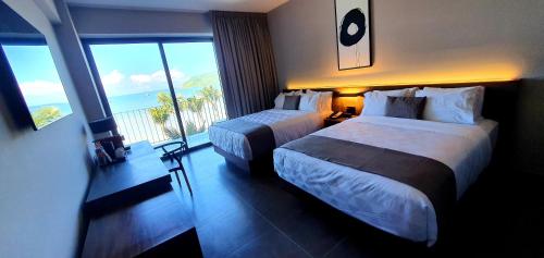 马萨特兰Viaggio Resort Mazatlán的酒店客房设有两张床和大窗户。