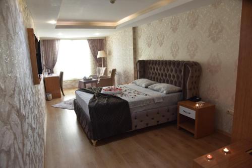 伊斯肯德伦巴亚兹特酒店的一间卧室配有一张床、一张桌子和一个窗户。