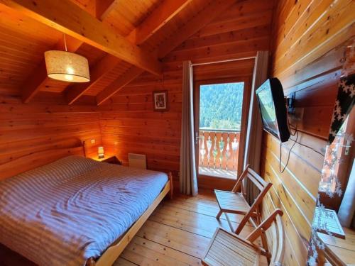 沙泰勒Chalet individuel 8 pers à Chatel Porte du soleil avec Jacuzzi exterieur的小屋内一间卧室配有一张床和电视