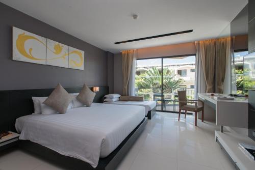 芭东海滩Patong Beachfront Studio 2 Mins Walk 2 Patong Beach的酒店客房设有两张床和一个阳台。