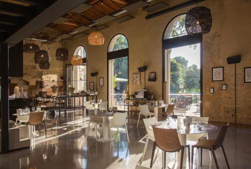 蒙彼利埃比阿尔住宿加早餐旅馆的餐厅设有桌椅和大窗户。