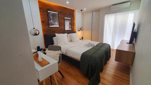 普拉亚Appart Dolce Vita à Praia的一间卧室配有一张床和一台电视