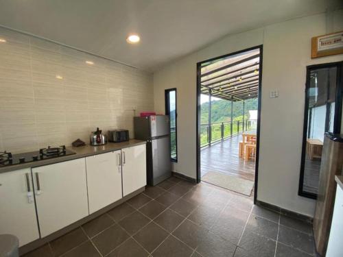 昆达桑Bayu Senja Lodge的带冰箱的厨房和通往天井的门