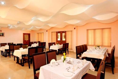 ChakkarakkalBROAD BEAN Chakkarakkal的餐厅配有桌椅和白色桌布