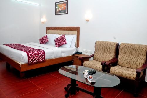 ChakkarakkalBROAD BEAN Chakkarakkal的酒店客房配有一张床、两把椅子和一张桌子