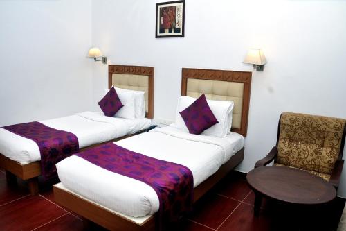 ChakkarakkalBROAD BEAN Chakkarakkal的酒店客房,配有两张床和椅子