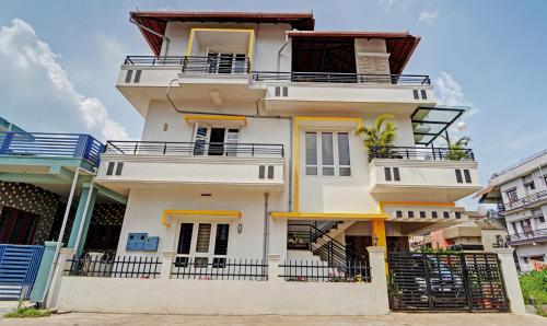 马迪凯里Treebo Trend Alaka Rester Homestay的带阳台的高高的白色房屋