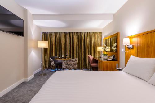 塔拉特格拉斯豪斯酒店的配有一张床和一张书桌的酒店客房