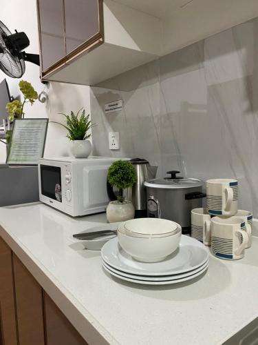碧瑶White Oak Residences - Baguio Megatower 3的厨房柜台配有盘子和微波炉