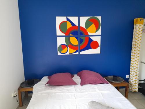 厄唐萨雷Chambre avec salle de bain, WC et terrasse的蓝色的卧室,配有一张壁画床
