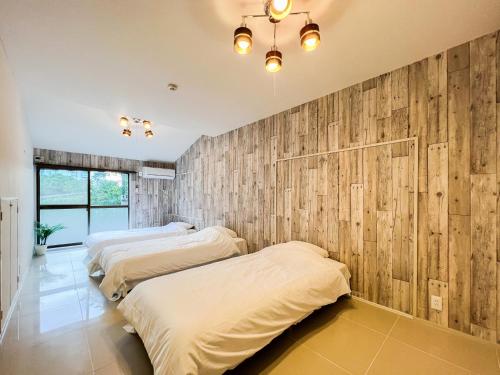 志摩市UMIBE IseShima的木镶板客房内的两张床